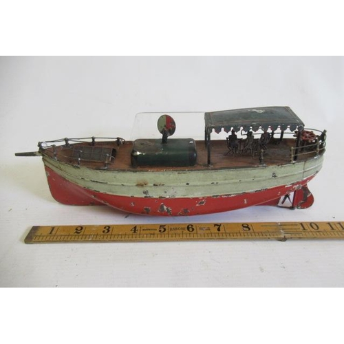 483 - A Carrett clockwork pleasure boat with tin canopy and passengers, clockwork motor tested satisfactor... 