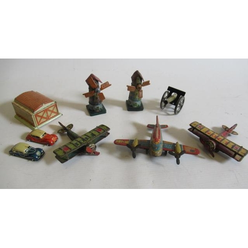 484 - Seven German small tinplate toys comprising three aircraft, two windmills, field gun and garage with... 