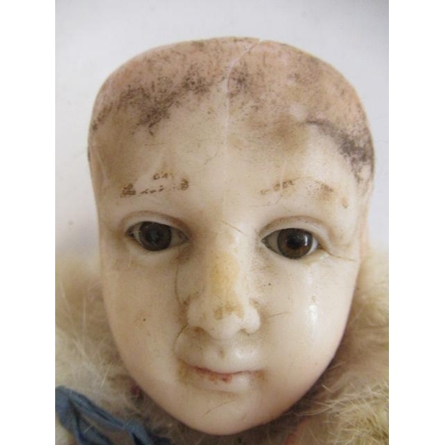 5 - A Victorian wax head doll, with brown glass fixed eyes, closed mouth, composition lower limbs, mould... 