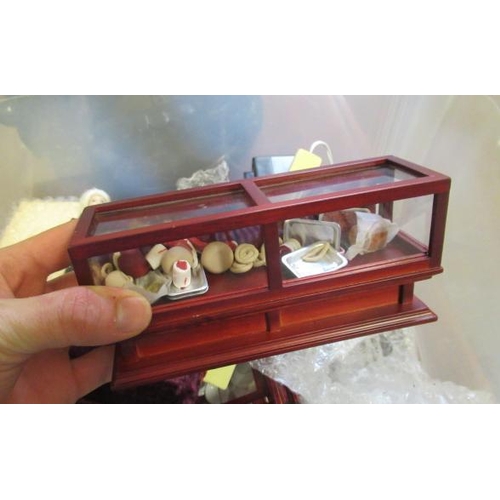 53 - A box of dolls house furniture, including mainly wooden furniture, two dolls and a small box of shop... 