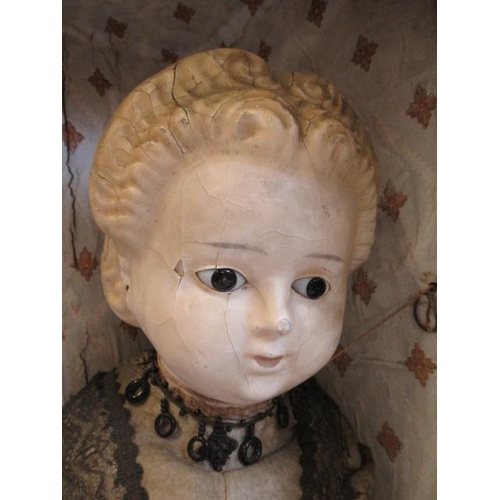 80 - A wax head doll, c.1890. with fixed glass eyes, moulded blond hair, closed mouth, cloth body, wooden... 