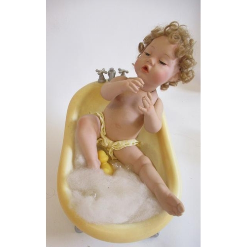 84 - Five Ashton Drake baby dolls, all ceramic with jointed necks, shoulders and hips, one in a bath tub,... 