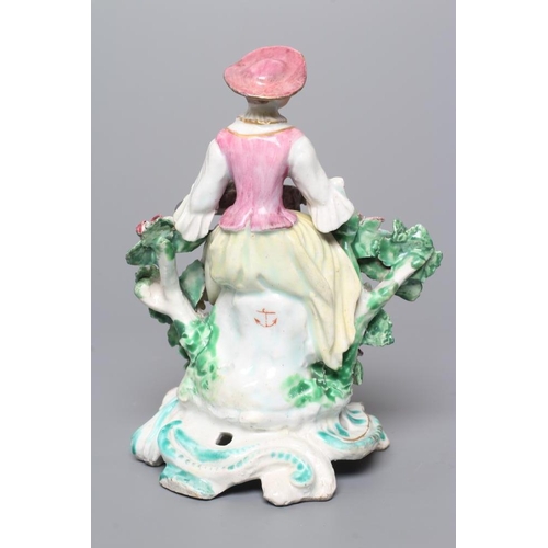 37 - A BOW PORCELAIN FIGURE, c.1760, modelled as Columbine, seated and wearing colourful clothing, playin... 