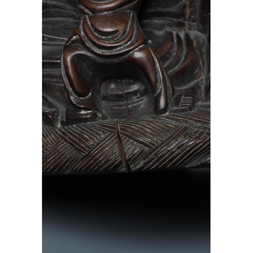 653 - A CHINESE CARVED HARDWOOD BUDDAH, seated wearing a long bead necklace and with three children in att... 