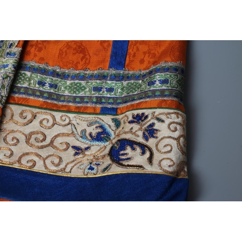 654 - A CHINESE SILK SKIRT PANEL, the burnt orange gores with bright blue seams, with blue and gold thread... 