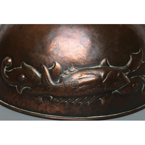 655 - A NEWLYN COPPER PEDESTAL BOWL, early 20th century, hammered with a band of three scaly fish on a pla... 