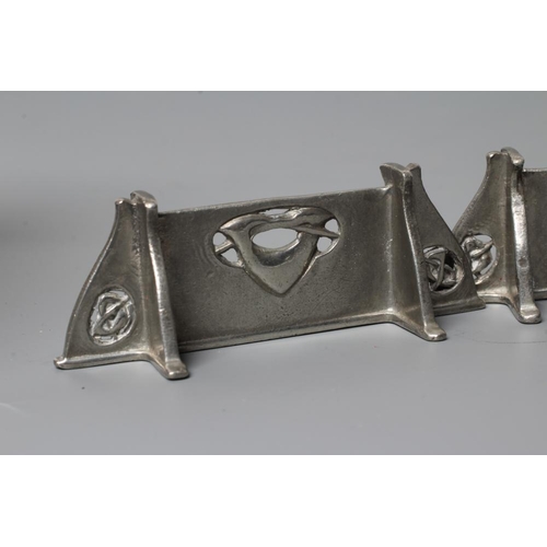 657 - ARCHIBALD KNOX FOR LIBERTY - a pair of pewter knife rests, of oblong form and pierced with entrelacs... 