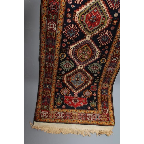 661 - A PERSIAN TRIBAL RUG, the navy blue field with five linked medallions in shades of green, pale blue,... 