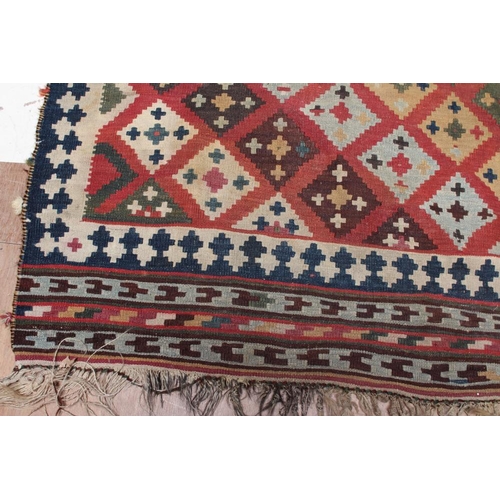 667 - A KILIM RUG, the madder field with diagonal rows of diamonds in alternating colours of shades of blu... 