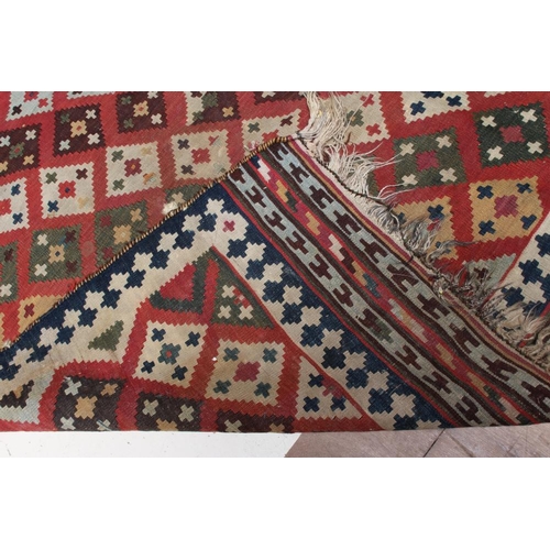 667 - A KILIM RUG, the madder field with diagonal rows of diamonds in alternating colours of shades of blu... 