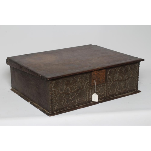 669 - AN OAK BOARDED BOX, c.1700, the hinged lid with punched banding, the fascia carved with trailing fol... 