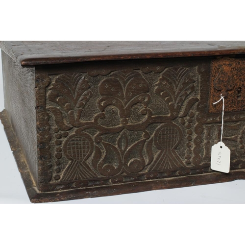 669 - AN OAK BOARDED BOX, c.1700, the hinged lid with punched banding, the fascia carved with trailing fol... 