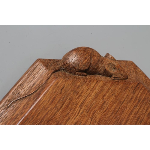 689 - A ROBERT THOMPSON ADZED OAK BREAD BOARD of canted oblong form, the moulded edge with carved mouse tr... 