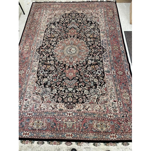 690 - A PERSIAN RUG, the black field with rose pink gul and ivory spandrels within a pale blue border with... 