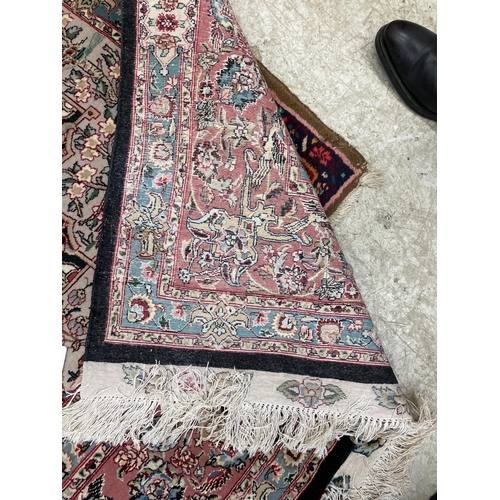 690 - A PERSIAN RUG, the black field with rose pink gul and ivory spandrels within a pale blue border with... 