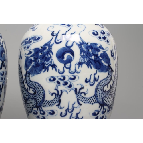 8 - A PAIR OF CHINESE PORCELAIN VASES of inverted baluster form, painted in underglaze blue with two dra... 