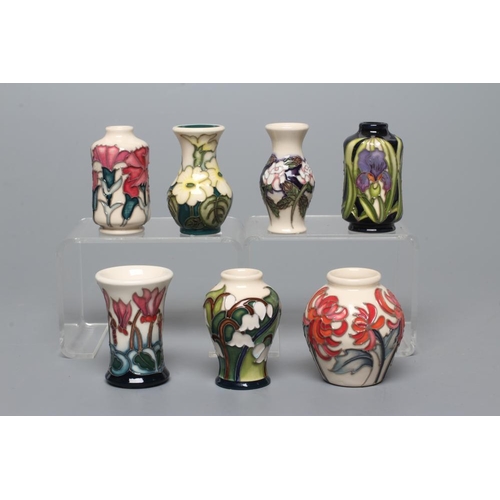 82 - SEVEN MINIATURE MOORCROFT POTTERY VASES, comprising Months of the Year January-Carnation, March-Prim... 