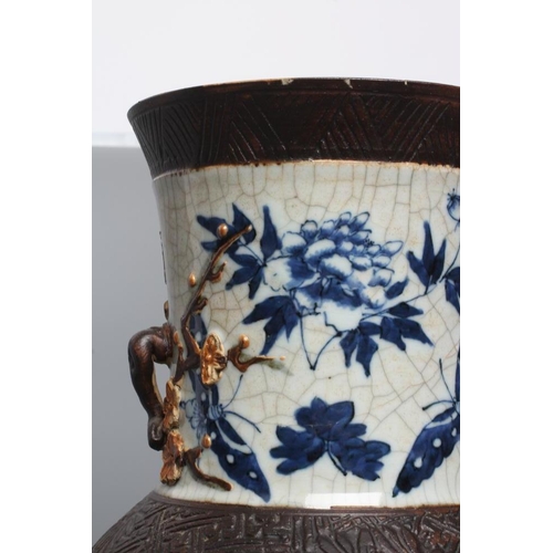 9 - A CHINESE CRACKLE GLAZE VASE with two lug handles, painted in underglaze blue with scattered flowers... 