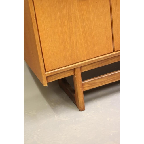 875 - A TEAK LONG SIDEBOARD, mid 20th century, the moulded edged top over three central drawers, one fitte... 