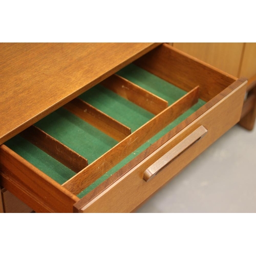 875 - A TEAK LONG SIDEBOARD, mid 20th century, the moulded edged top over three central drawers, one fitte... 