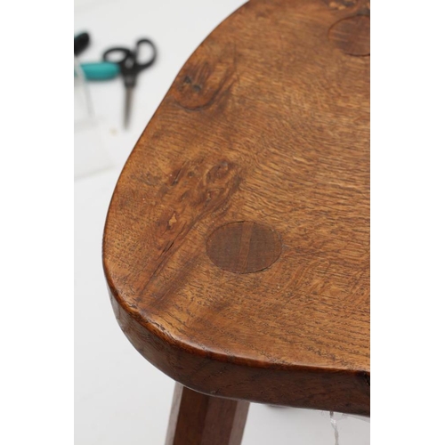 883 - A ROBERT THOMPSON OAK STOOL, the saddle seat with carved mouse trademark in high relief to the edge,... 