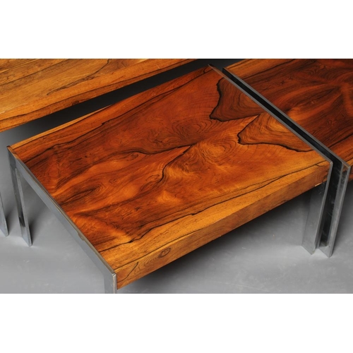 884 - A NEST OF ROSEWOOD COFFEE TABLES, mid 20th century, of oblong form on square section chrome plated l... 