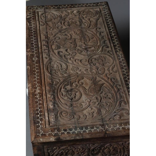 914 - AN INDIAN CARVED WOOD CHEST of oblong form with panels of birds amongst foliate scrolls and with mot... 