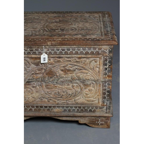 914 - AN INDIAN CARVED WOOD CHEST of oblong form with panels of birds amongst foliate scrolls and with mot... 