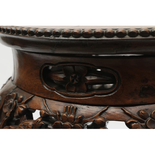 919 - A CHINESE PADOUK WOOD STAND, c.1900, the beaded edged circular top inset with rouge marble, arched f... 