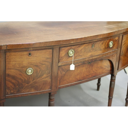 924 - A REGENCY MAHOGANY SIDEBOARD, early 19th century, of bowed form with ebony stringing, frieze drawer ... 