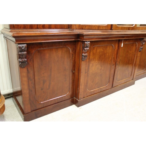 926 - A VICTORIAN MAHOGANY BREAKFRONT LIBRARY BOOKCASE, the moulded cornice over four arched glazed doors,... 