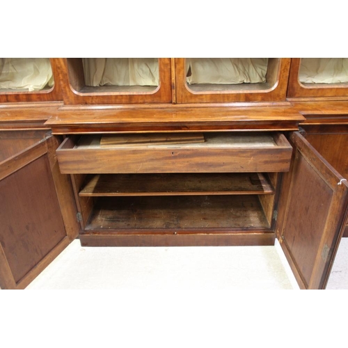 926 - A VICTORIAN MAHOGANY BREAKFRONT LIBRARY BOOKCASE, the moulded cornice over four arched glazed doors,... 