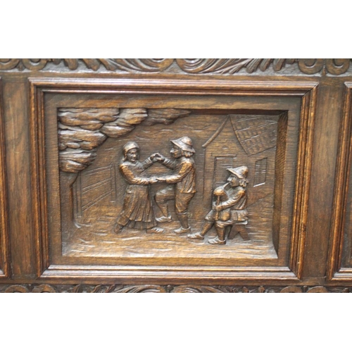 942 - A VICTORIAN CARVED OAK BOX SETTLE, the triple panelled back depicting figure scenes in high relief b... 