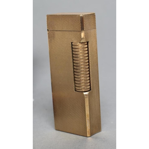 152 - A DUNHILL 9CT GOLD ROLLAGAS CIGARETTE LIGHTER of plain oblong form with engine turning, 2 1/2