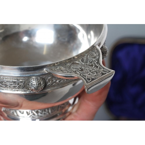 216 - AN EDWARDIAN SILVER CELTIC STYLE PORRINGER, maker Reid & Sons, London 1910, of circular form, the tw... 