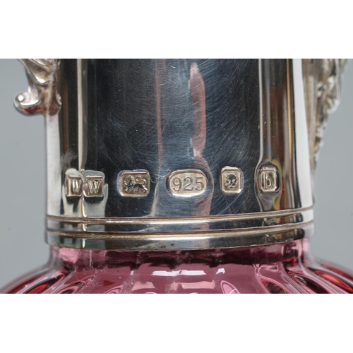 279 - A SILVER MOUNTED CRANBERRY GLASS CLARET JUG, maker's mark WW, London 2001, the lightly ribbed ovoid ... 