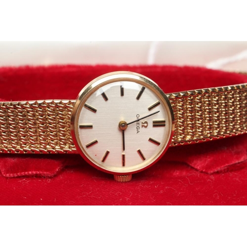 414 - A LADY'S 9CT GOLD OMEGA WRISTWATCH, the pale champagne dial with applied gilt metal batons, in a pla... 