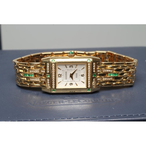 421 - A LADY'S JAEGER-LECOULTRE EMERALD AND DIAMOND REVERSO WRISTWATCH/BRACELET, the oblong silvered dial ... 