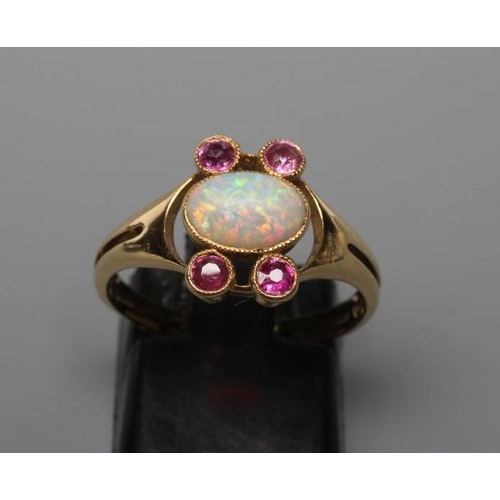 428 - A MURRLE BENNETT DRESS RING, the oval cabochon polished opal collet set with two pairs of small rubi... 