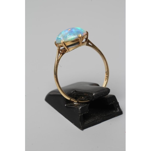 429 - T. GAUNT - a black opal ring, the oval cabochon polished stone claw set to a plain shank, stamped 15... 