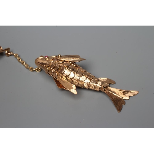 433 - A NOVELTY FISHING BROOCH, the scaley articulated fish with ruby eyes, on a chain 