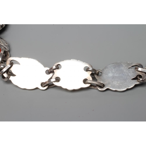 438 - A GEORG JENSEN SILVER NECKLACE, the repousse links as stylised buds and foliage, collet set with cab... 