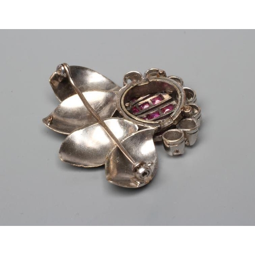 458 - A MODERNIST RUBY AND DIAMOND FLOWER BROOCH, the five petals channel set with calibre cut rubies with... 