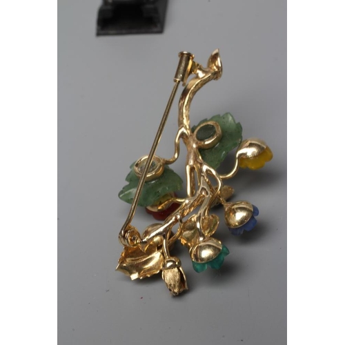 462 - A TUTTI-FRUTTI SPRAY BROOCH, stamped 585, with carved and polished semi precious flowerheads and lea... 