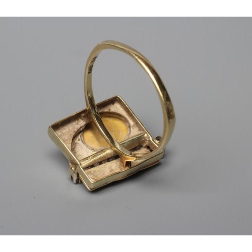 464 - A SECESSIONIST STYLE COCKTAIL RING, the square panel close back collet set with an oval cabochon pol... 