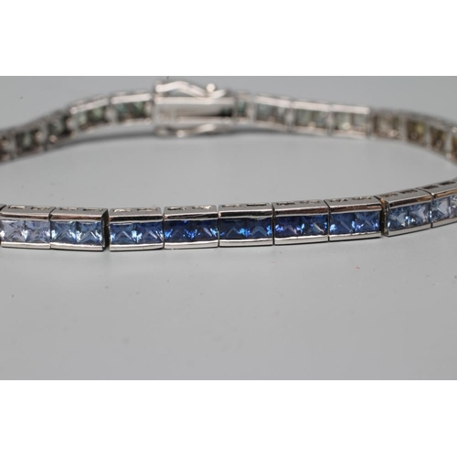 467 - A RAINBOW SAPPHIRE TENNIS BRACELET, compirising sixty eight calibre cut stones graduating through gr... 