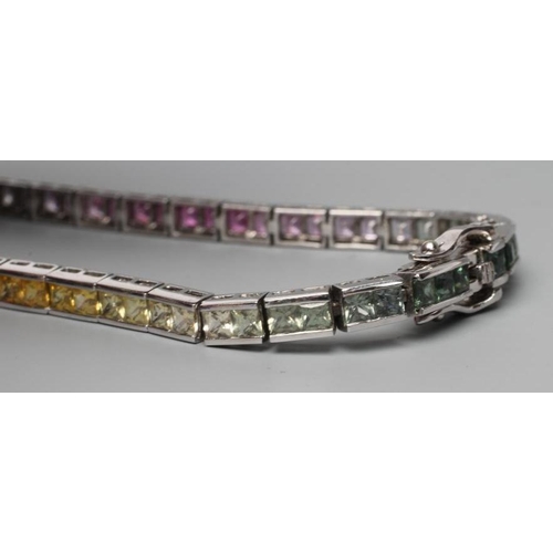 467 - A RAINBOW SAPPHIRE TENNIS BRACELET, compirising sixty eight calibre cut stones graduating through gr... 