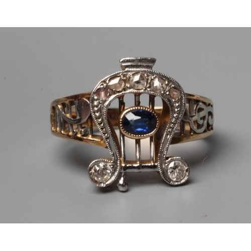 468 - AN EDWARDIAN SAPPHIRE AND DIAMOND RING, the diamond set lyre centred by an open back collet set oval... 