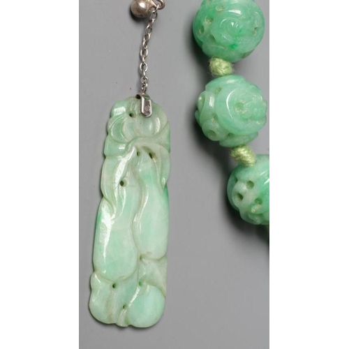 474 - A CHINESE JADE NECKLACE, the twenty nine spherical beads carved and pierced with scrolling foliage, ... 