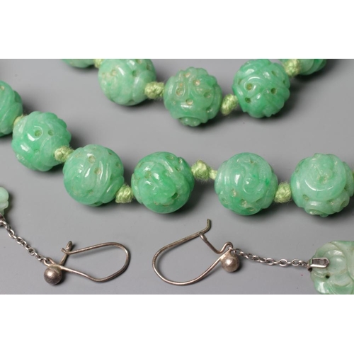 474 - A CHINESE JADE NECKLACE, the twenty nine spherical beads carved and pierced with scrolling foliage, ... 